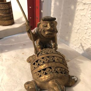 INDIO ENCIMA DE TORTUGA CON BASTON